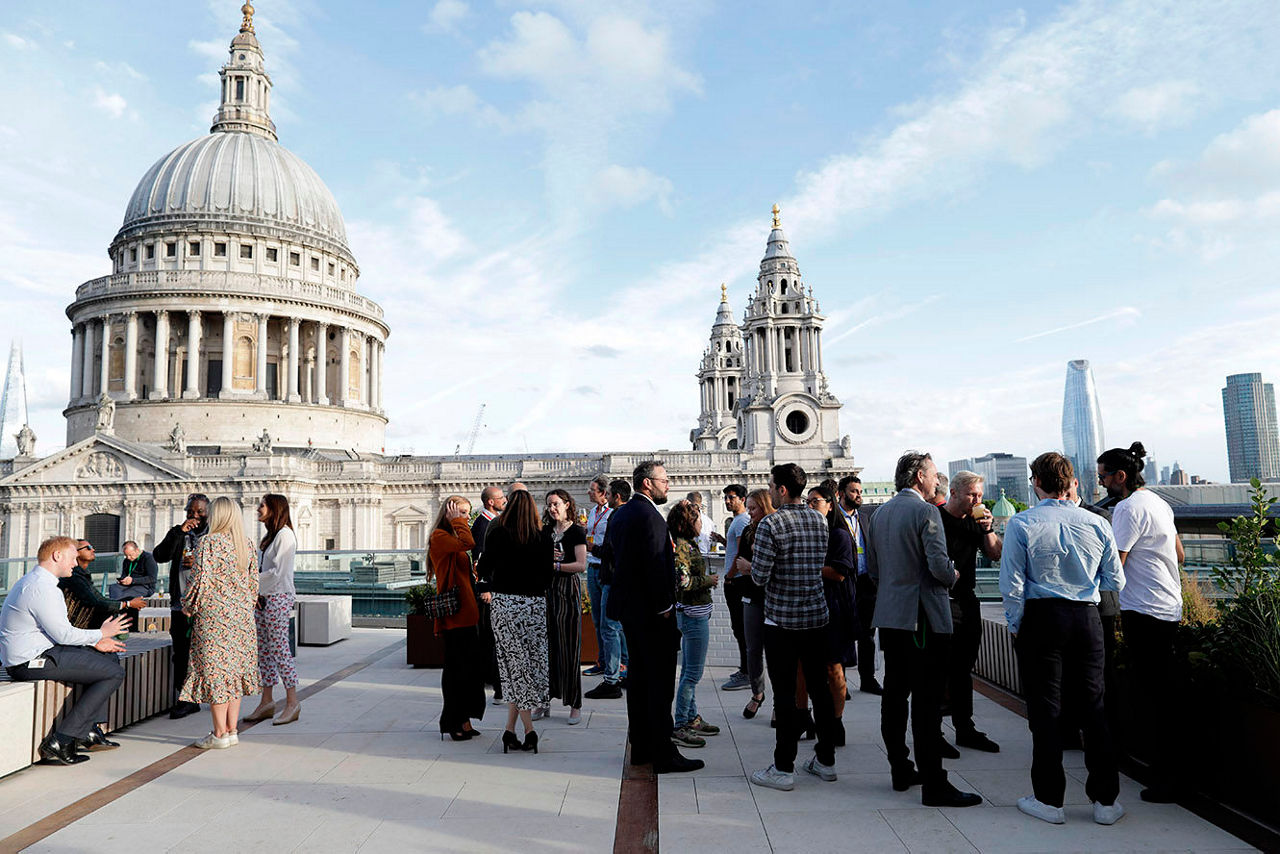 A group of people gathered on a rooftop terrace during a social event.