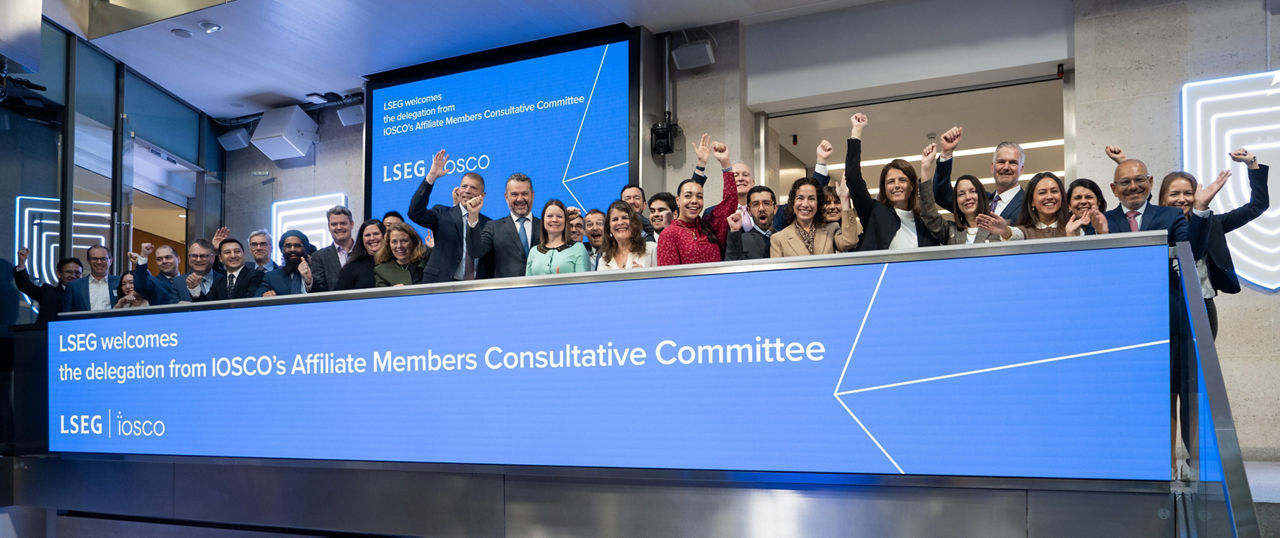 The team celebrating on the balcony at LSEG during the welcome ceremony.