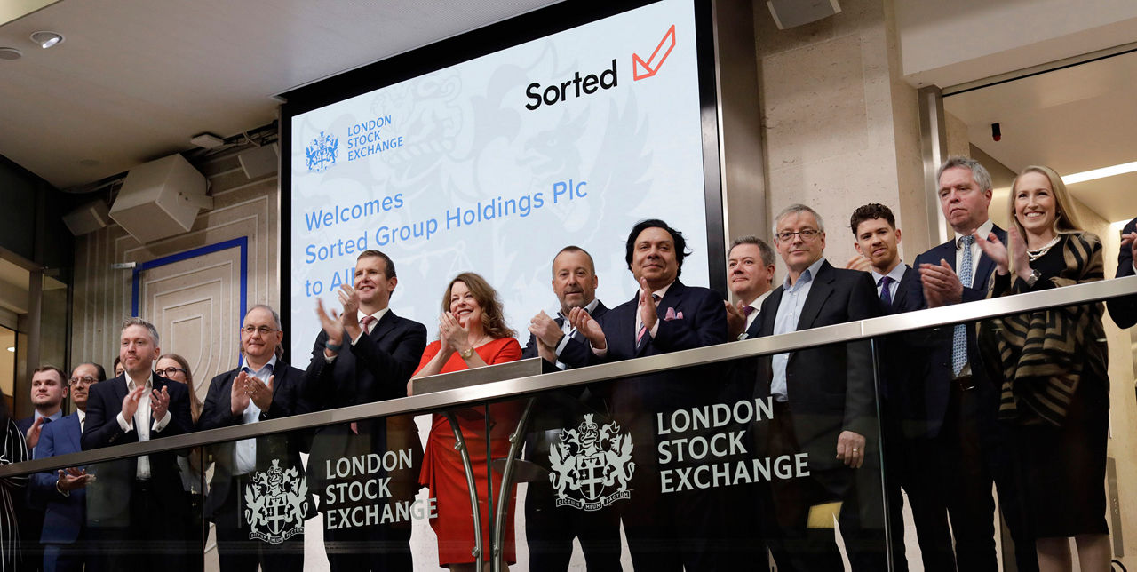The team celebrating on the balcony at LSEG during the welcome ceremony.